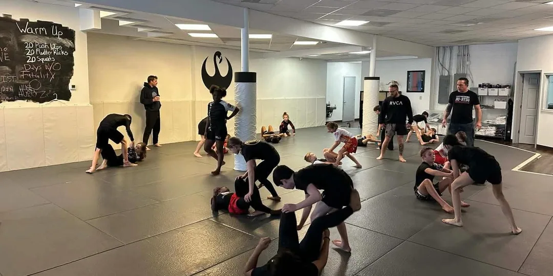 Two young students practising a controlled gi jiu jitsu position in the CPJJ kids class
